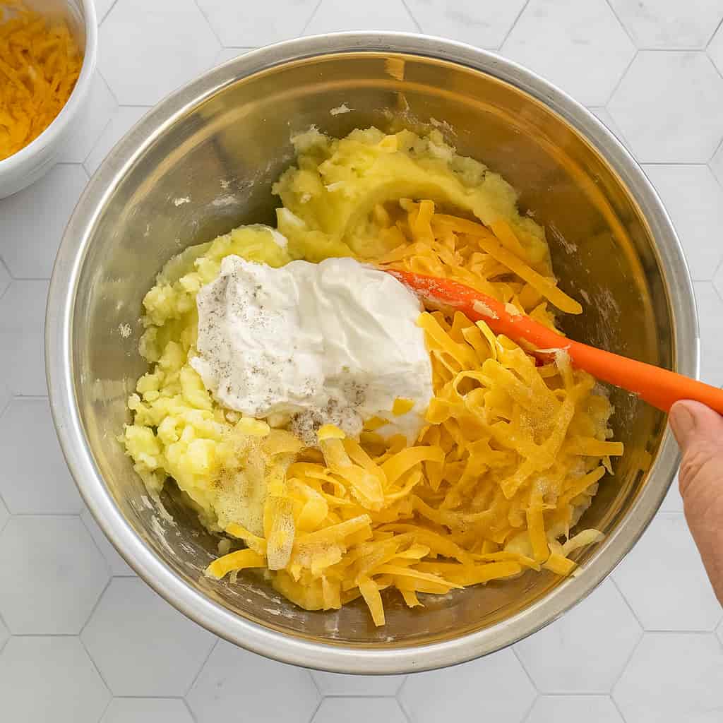 mashing potatoes with butter and cheese